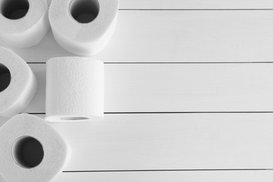 Photo of Many soft toilet paper rolls on white wooden table, flat lay. Space for text