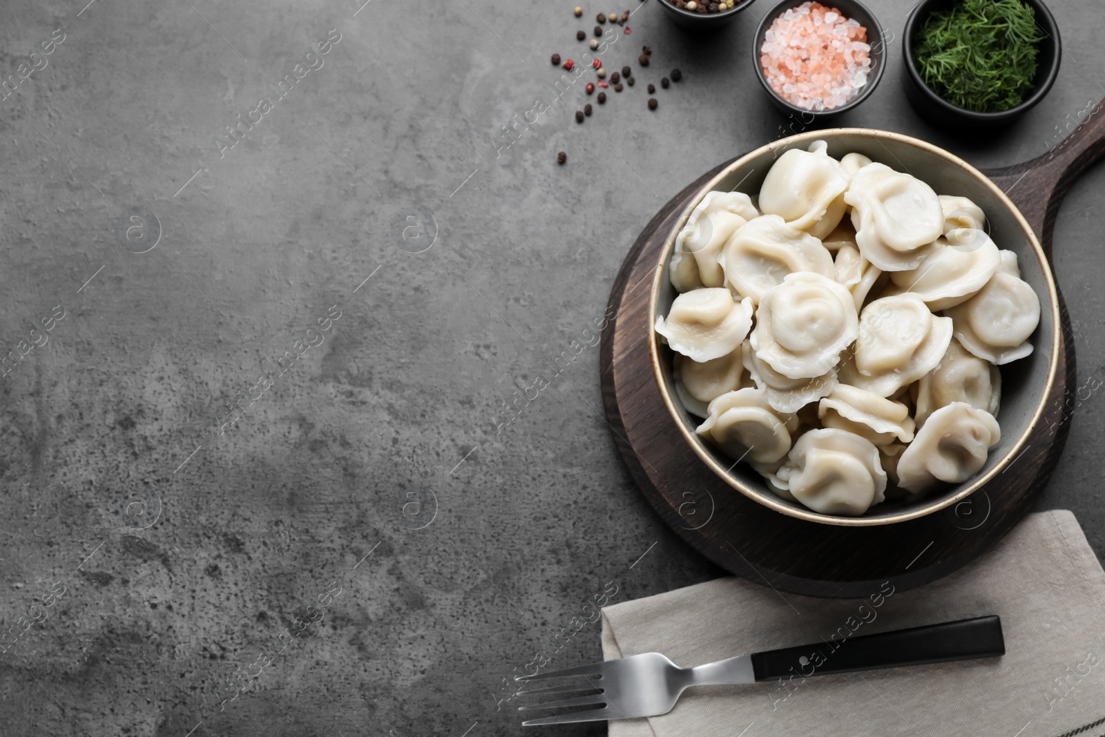Photo of Tasty dumplings in bowl served on table, flat lay. Space for text