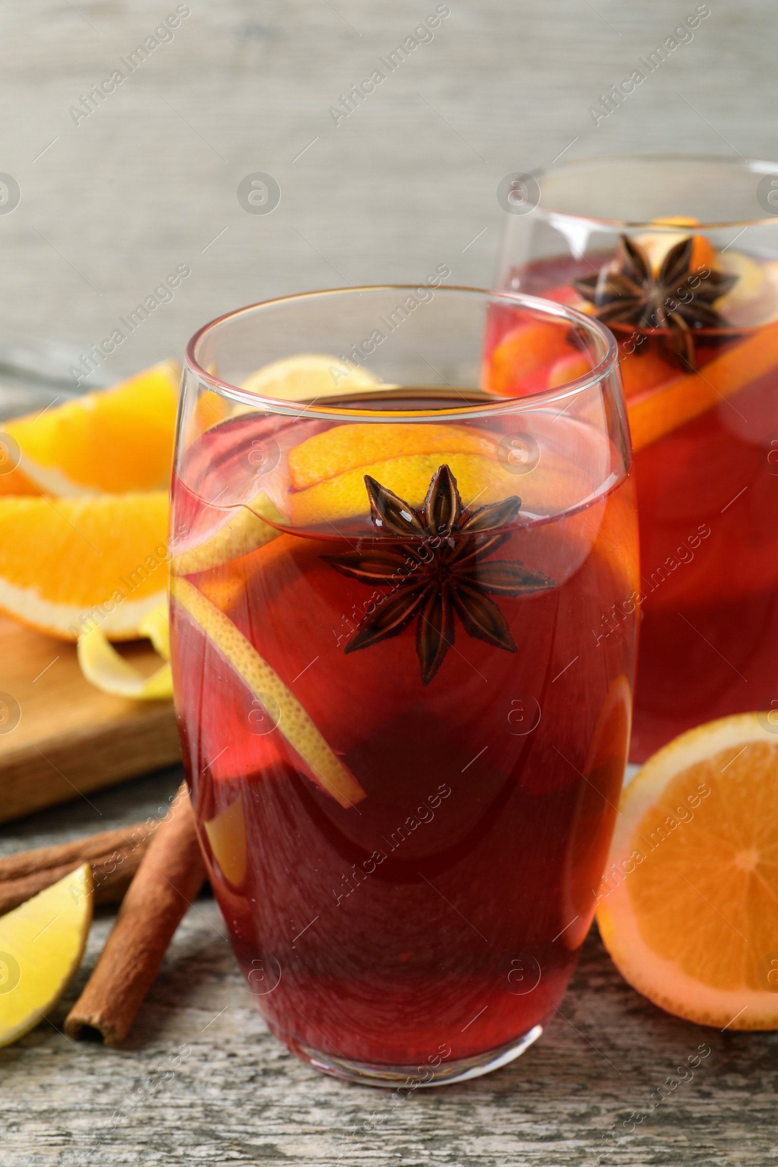 Photo of Aromatic punch drink and ingredients on wooden table