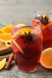 Photo of Aromatic punch drink and ingredients on wooden table