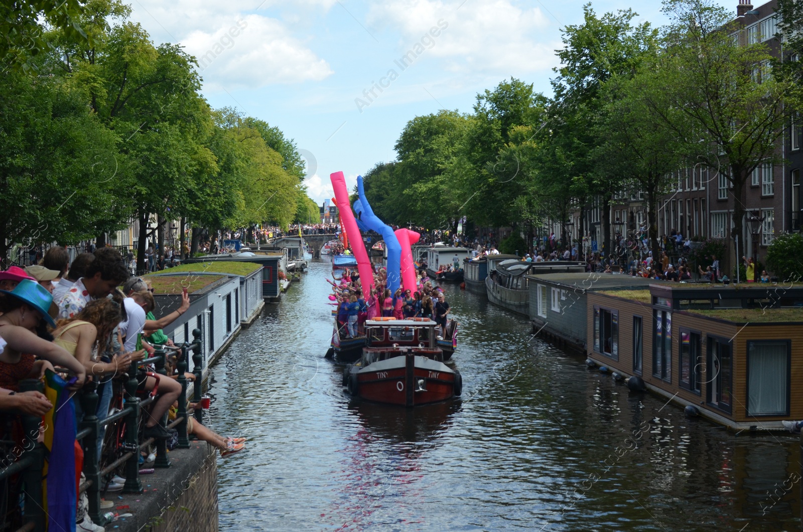 Photo of AMSTERDAM, NETHERLANDS - AUGUST 06, 2022: Many people in boats at LGBT pride parade on river