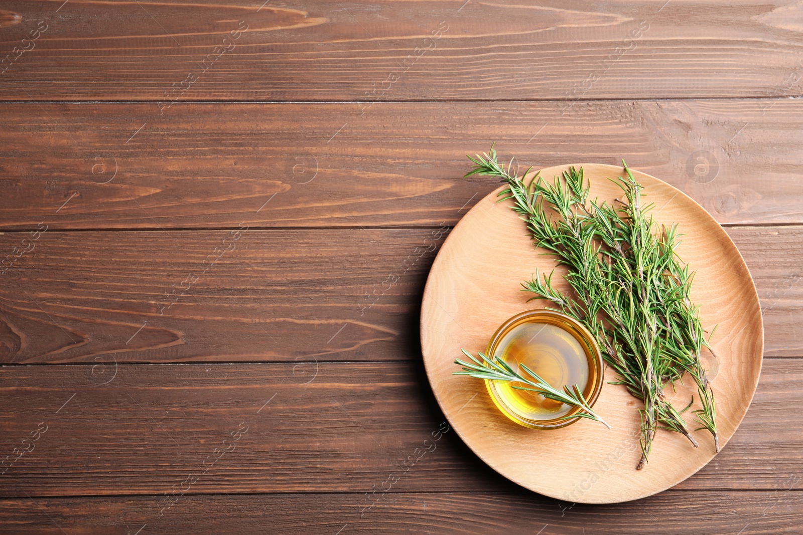 Photo of Flat lay composition with fresh rosemary oil on wooden background