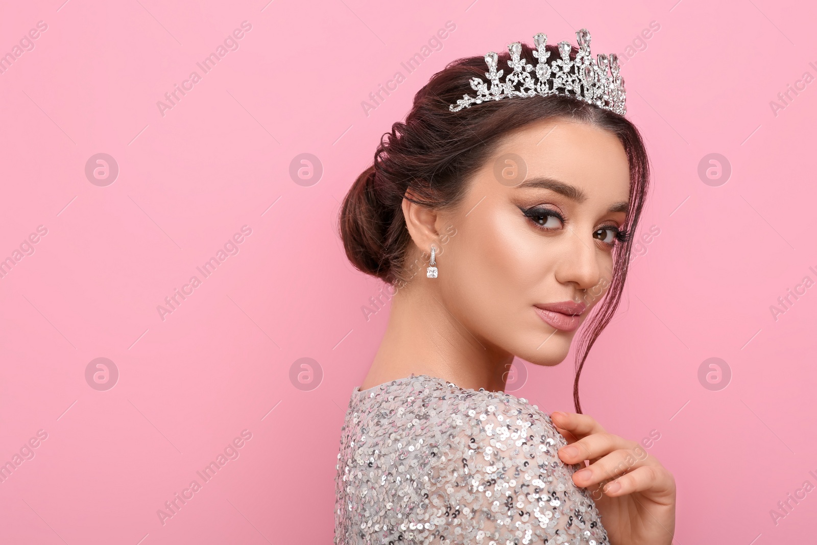 Photo of Beautiful young woman wearing luxurious tiara on pink background, space for text