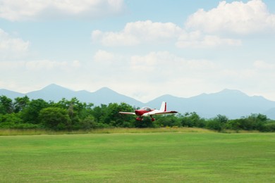 Photo of View of beautiful ultralight airplane flying above field