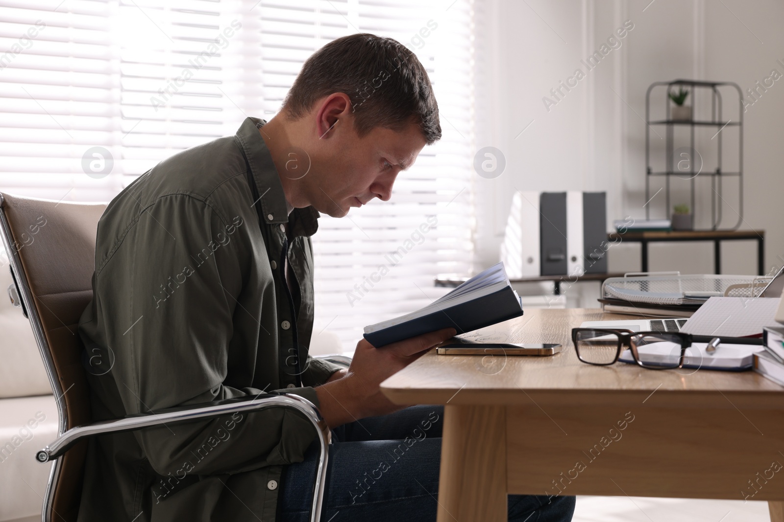 Photo of Man with bad posture working at table in office