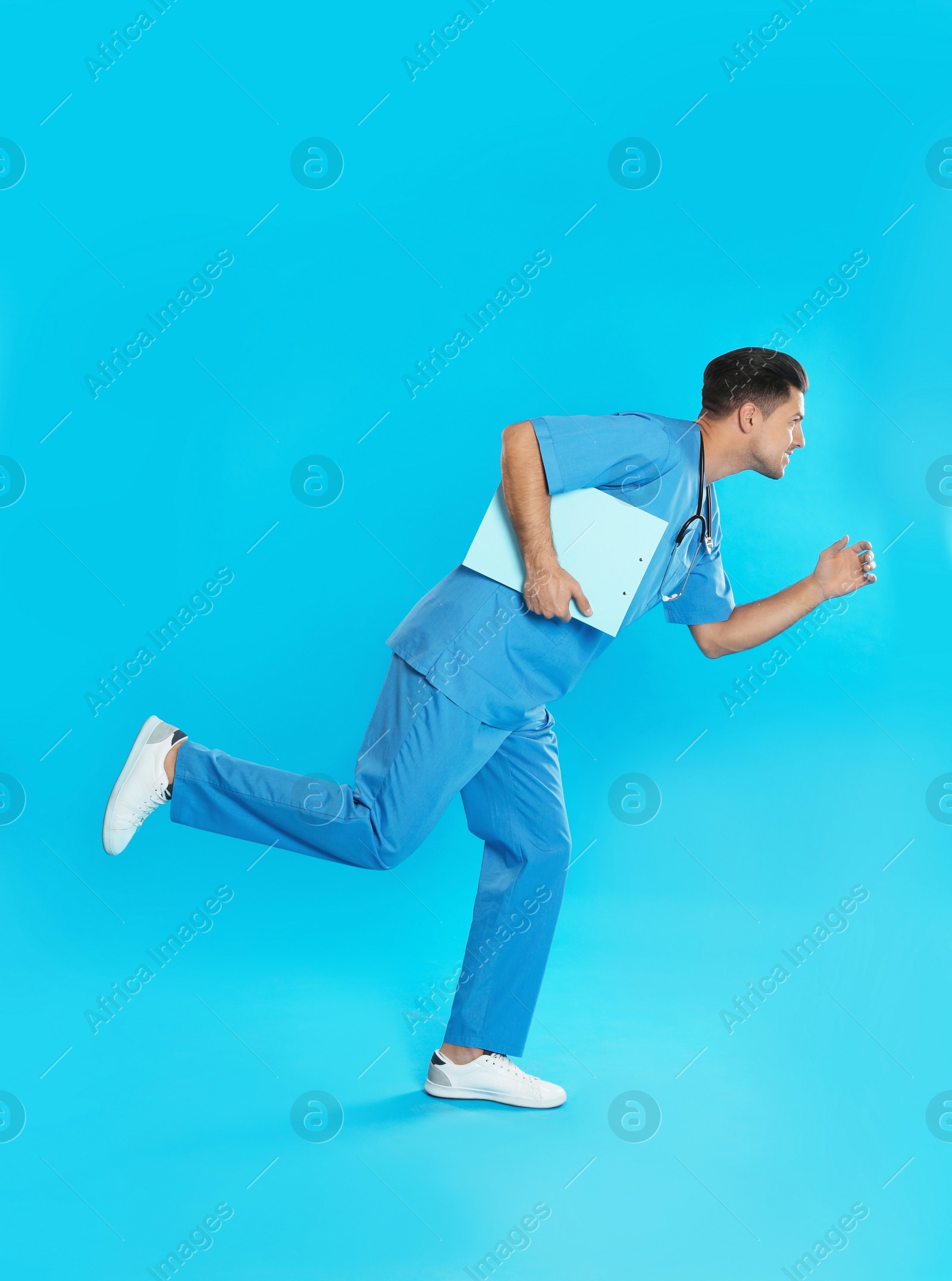 Photo of Doctor with clipboard running on blue background