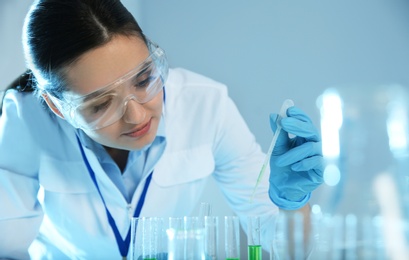 Photo of Female scientist working with sample in modern chemistry laboratory