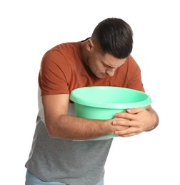 Photo of Man with basin suffering from nausea on white background. Food poisoning