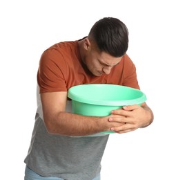 Man with basin suffering from nausea on white background. Food poisoning