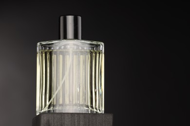 Luxury men`s perfume in bottle against dark background, space for text