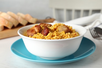 Photo of Bowl of tasty rice pilaf with meat served on table