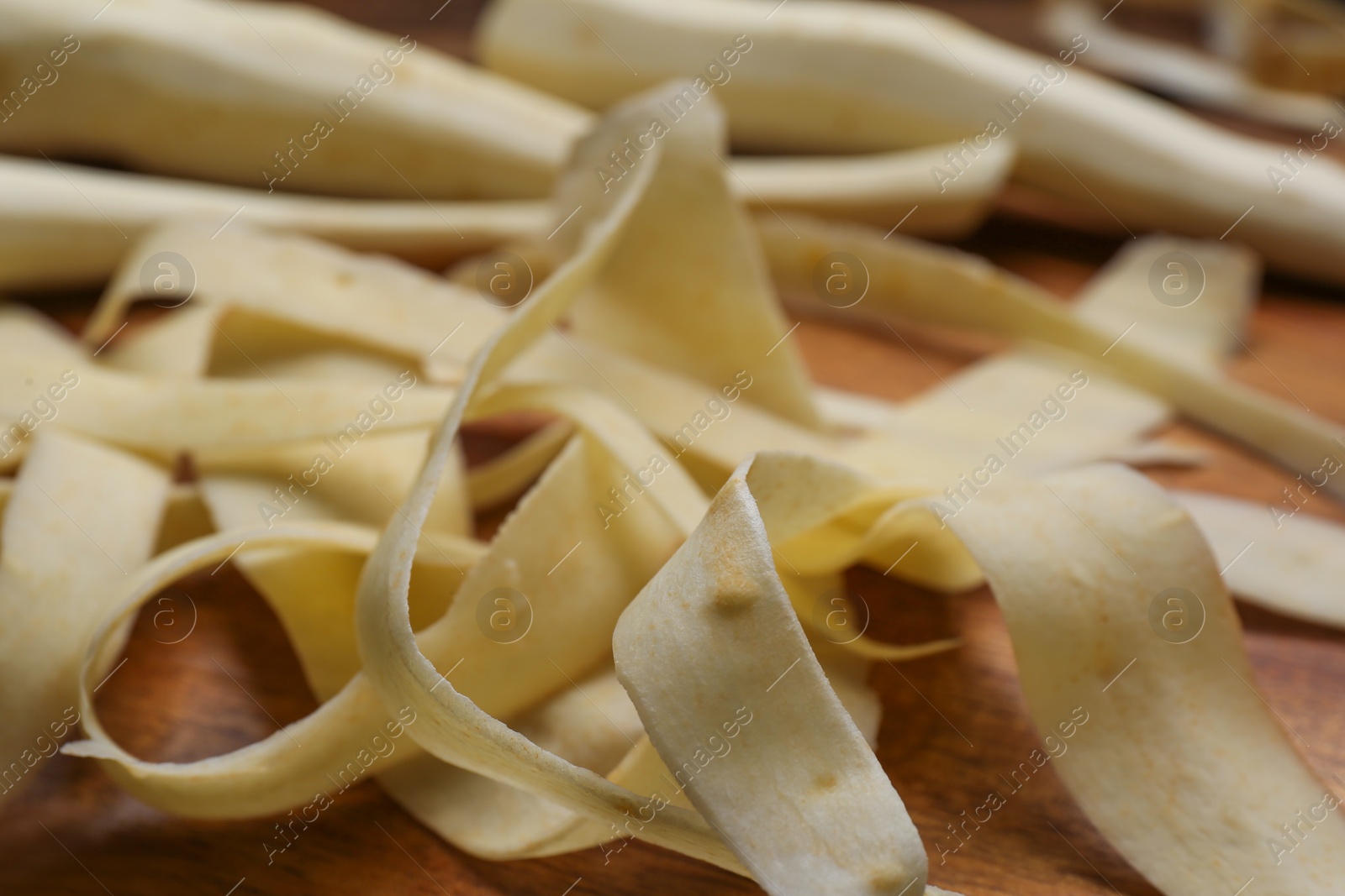 Photo of Sliced fresh parsnip on wooden board, closeup