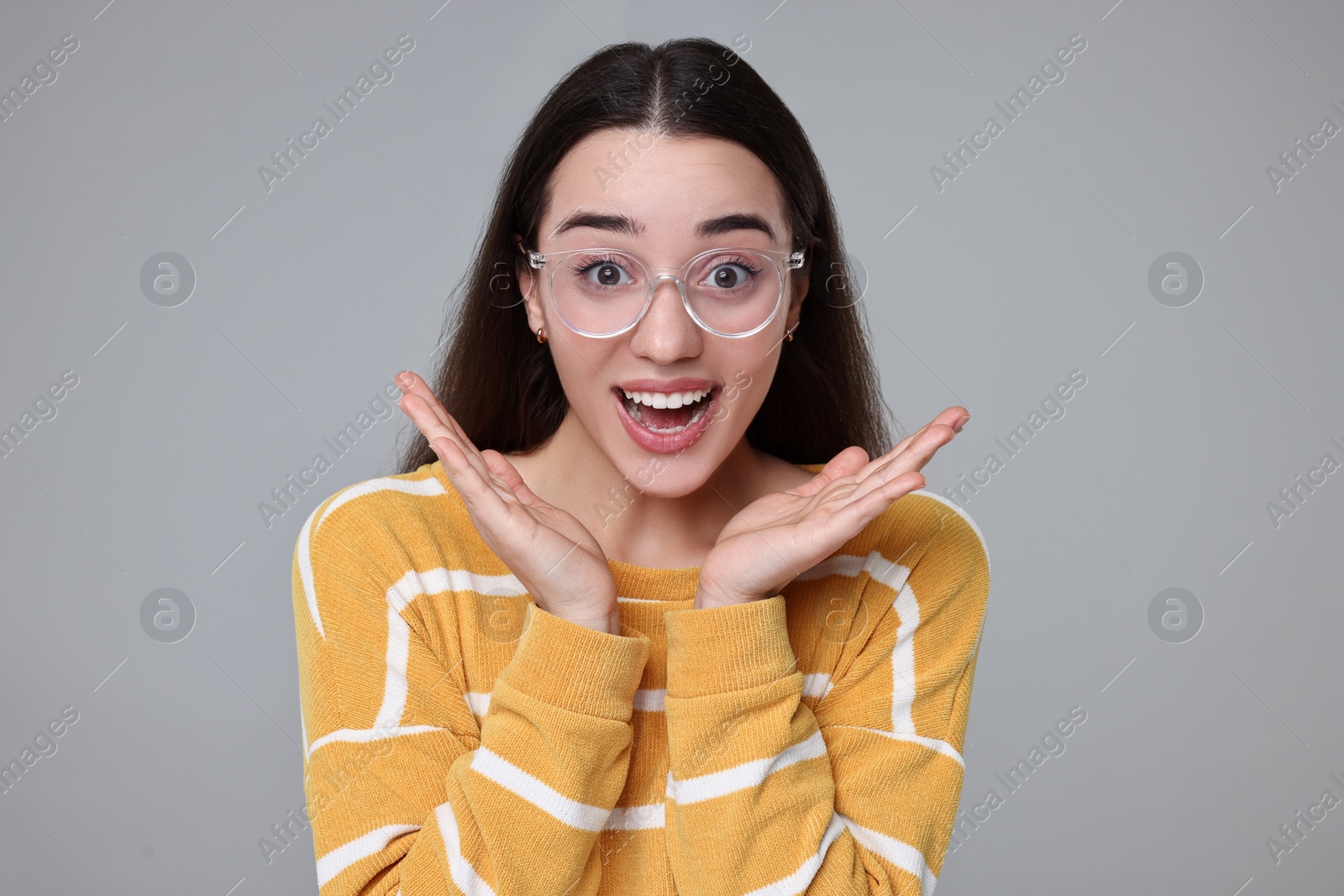 Photo of Portrait of happy surprised woman on grey background