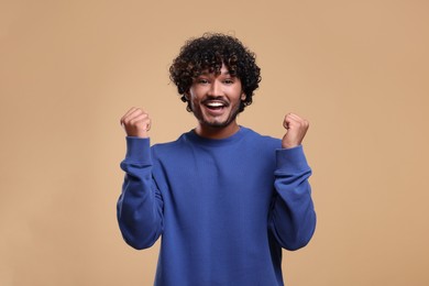 Handsome young happy man on beige background