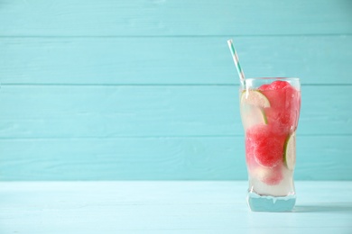 Glass of refreshing watermelon drink on blue wooden table. Space for text