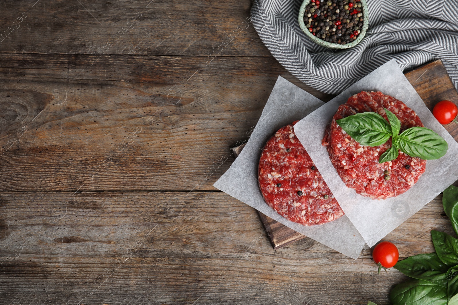 Photo of Flat lay composition with raw meat cutlets for burger on wooden table. Space for text