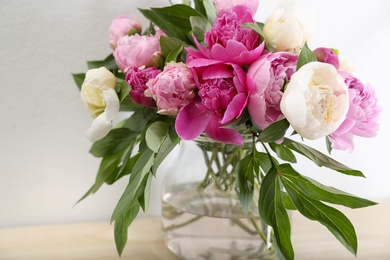 Photo of Vase with bouquet of beautiful peonies on table