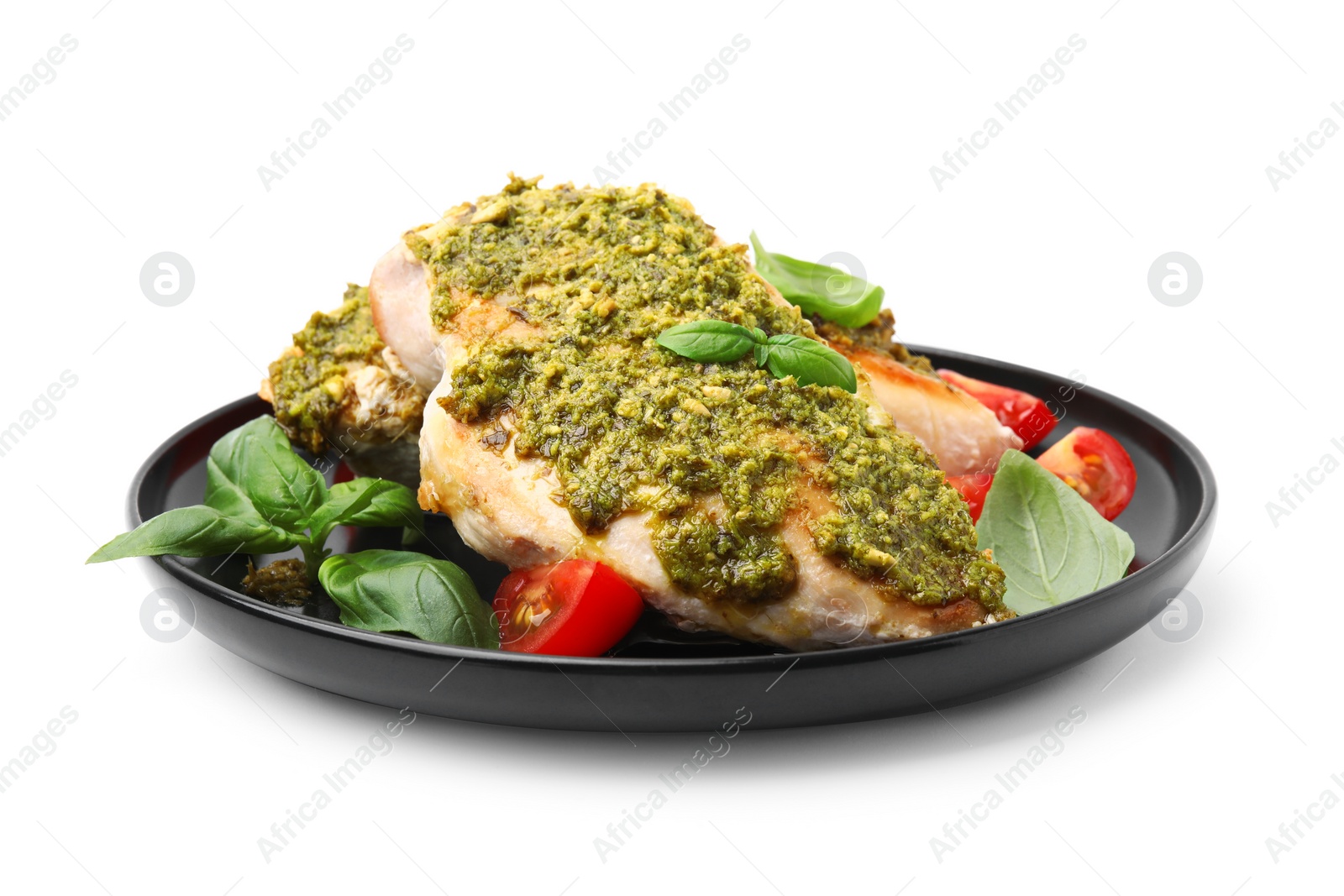 Photo of Delicious chicken breasts with pesto sauce, tomatoes and basil isolated on white