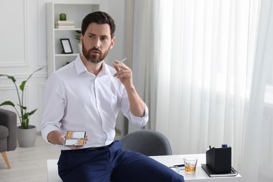 Man with cigarette and case in office