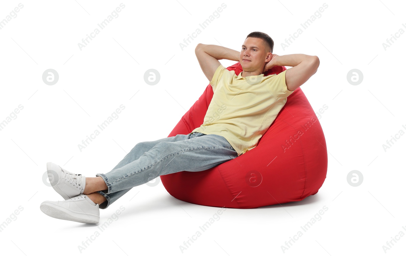 Photo of Handsome man resting on red bean bag chair against white background