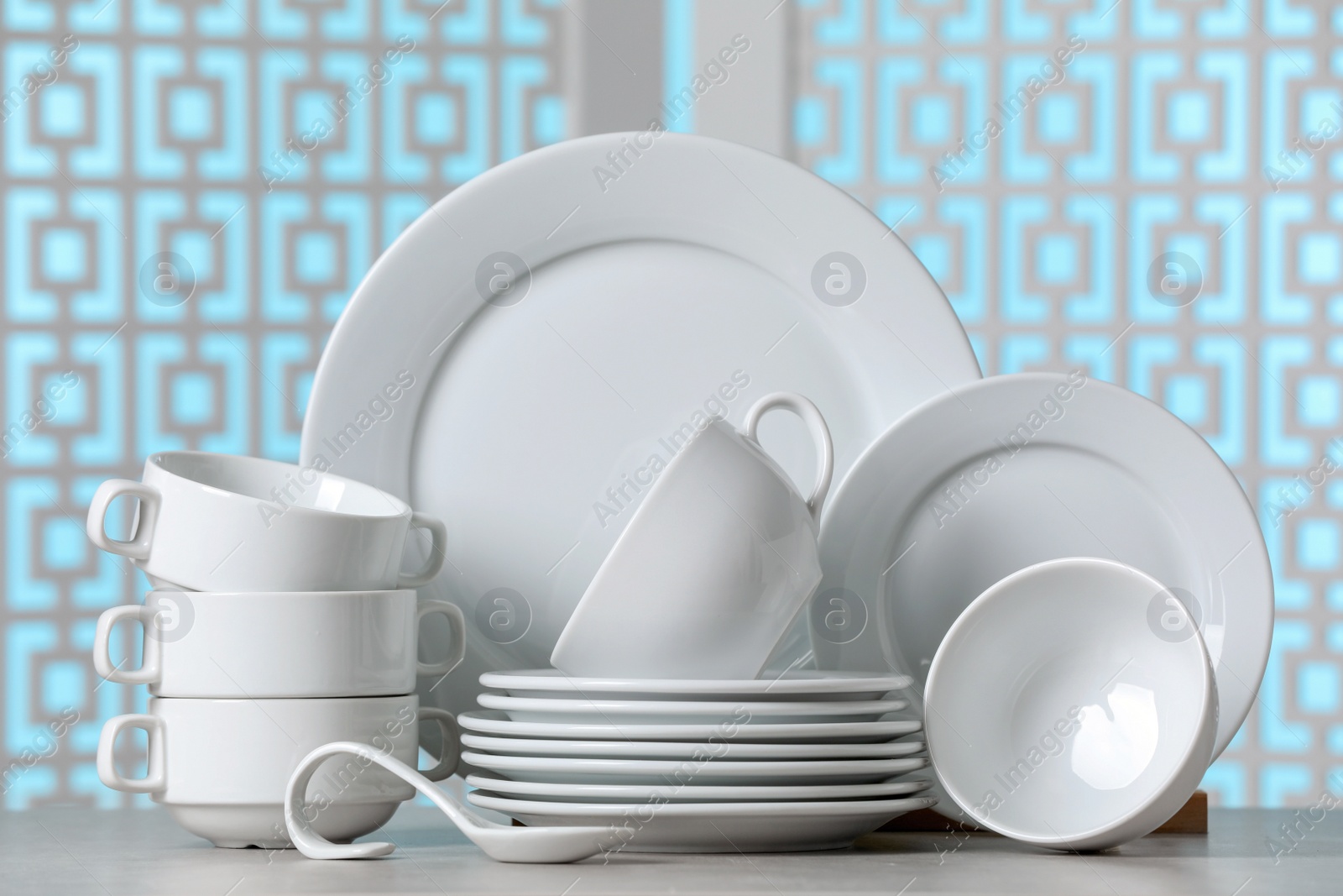 Photo of Set of clean dishware on light grey table