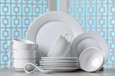 Set of clean dishware on light grey table