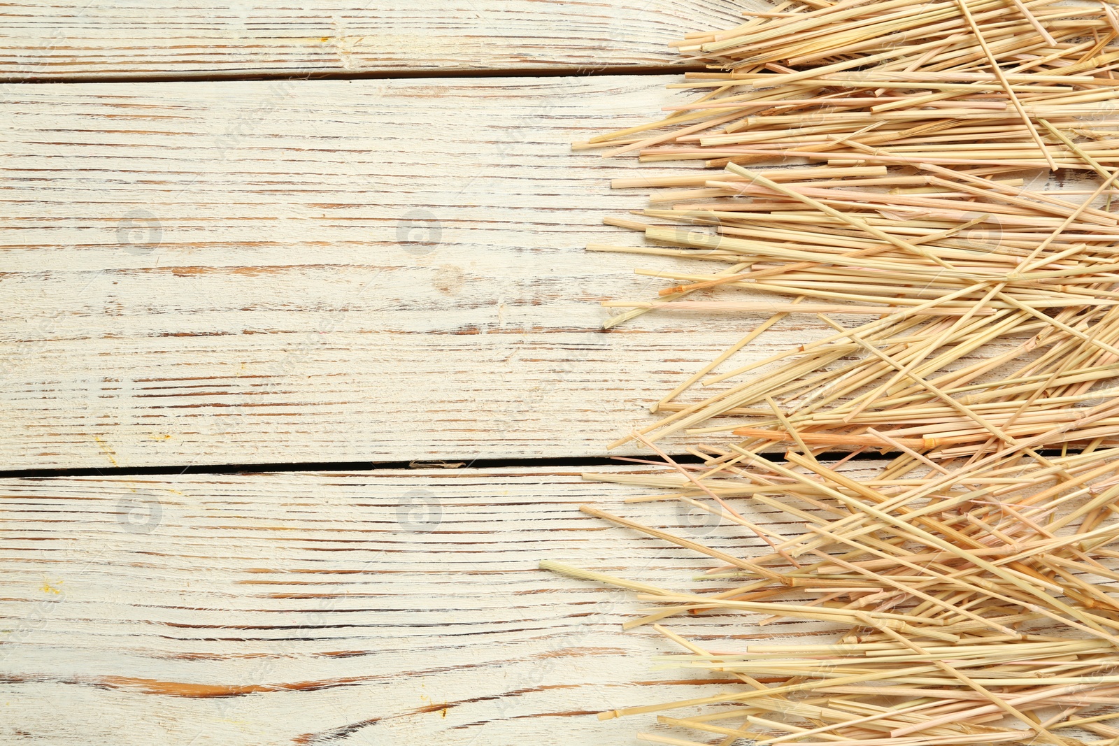 Photo of Heap of dried hay on white wooden background, flat lay. Space for text