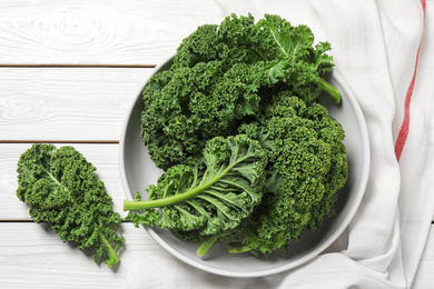 Fresh kale leaves on white wooden table, flat lay