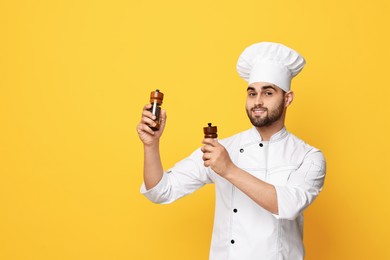 Photo of Professional chef with shakers on yellow background. Space for text