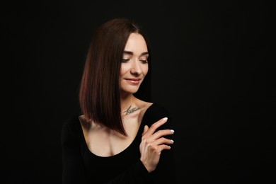 Photo of Portrait of pretty young woman with gorgeous chestnut hair on black background, space for text