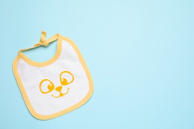 Photo of New baby bib on light blue background, top view. Space for text