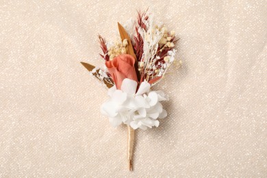 Stylish boutonniere on light fabric, top view