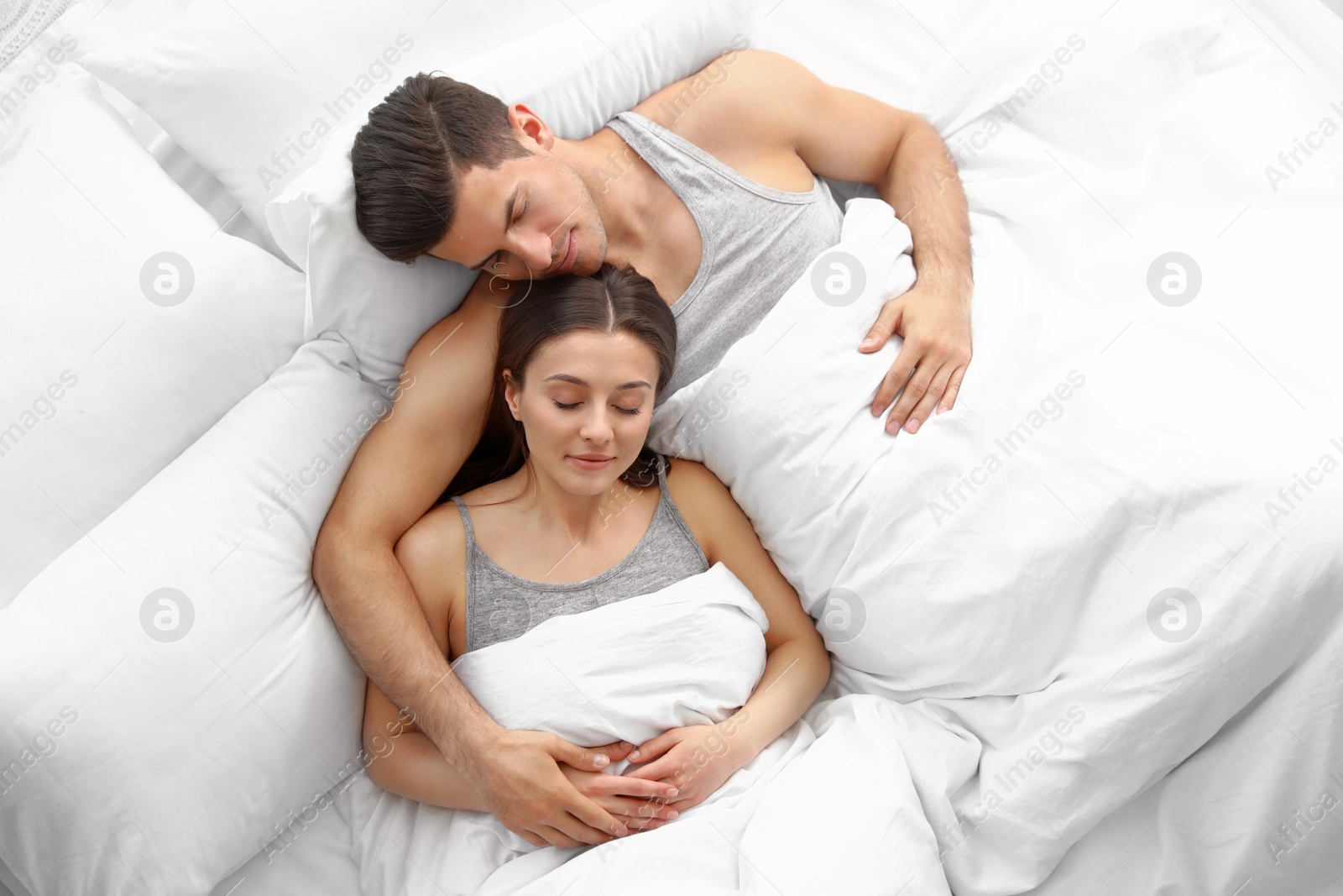 Photo of Lovely young couple sleeping in large bed, above view