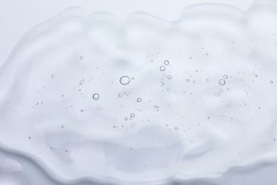 Photo of Sample of cosmetic oil on white background, closeup