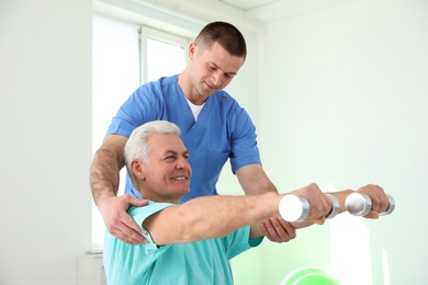 Photo of Professional physiotherapist working with senior patient in rehabilitation center