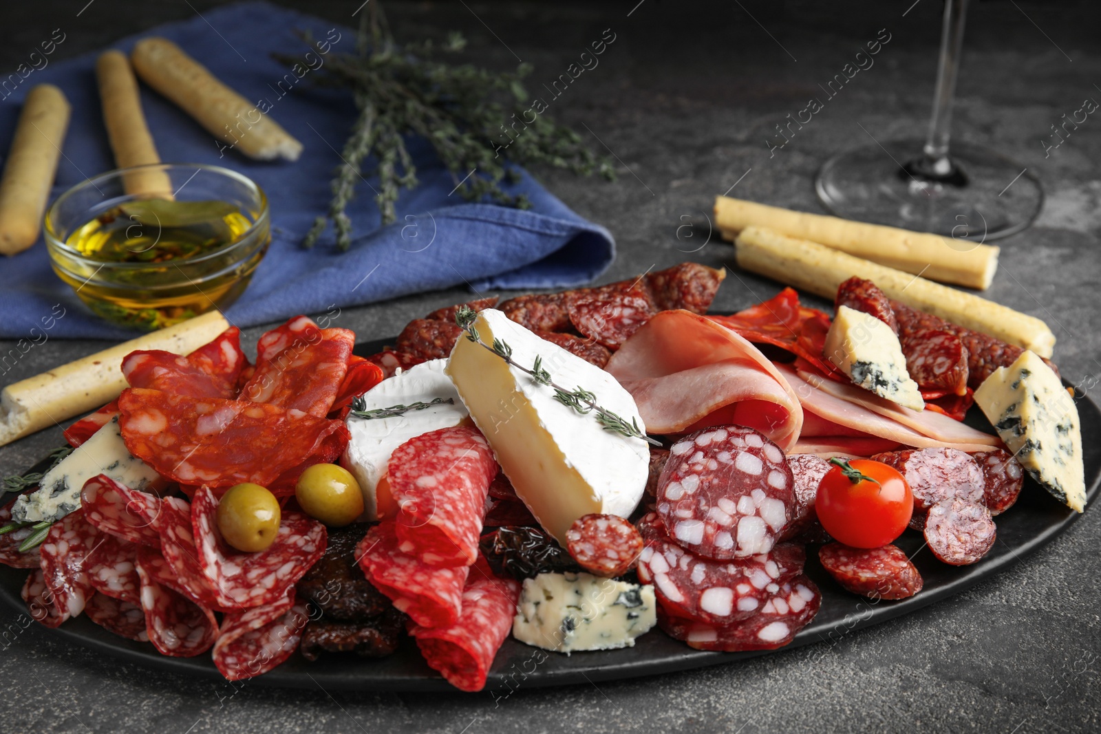 Photo of Tasty ham with other delicacies served on grey table
