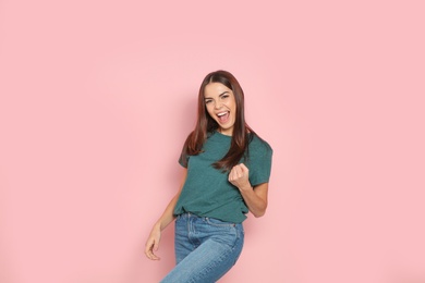 Photo of Young woman celebrating victory on color background