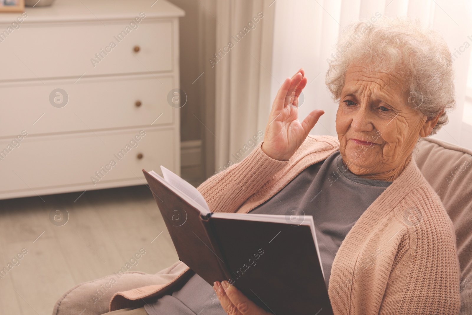 Photo of Senior woman with notebook at home, space for text. Age-related memory impairment