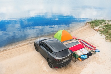 Car and camping equipment on sandy beach. Summer trip