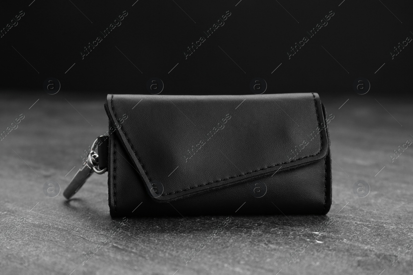 Photo of Stylish leather keys holder on grey table, closeup