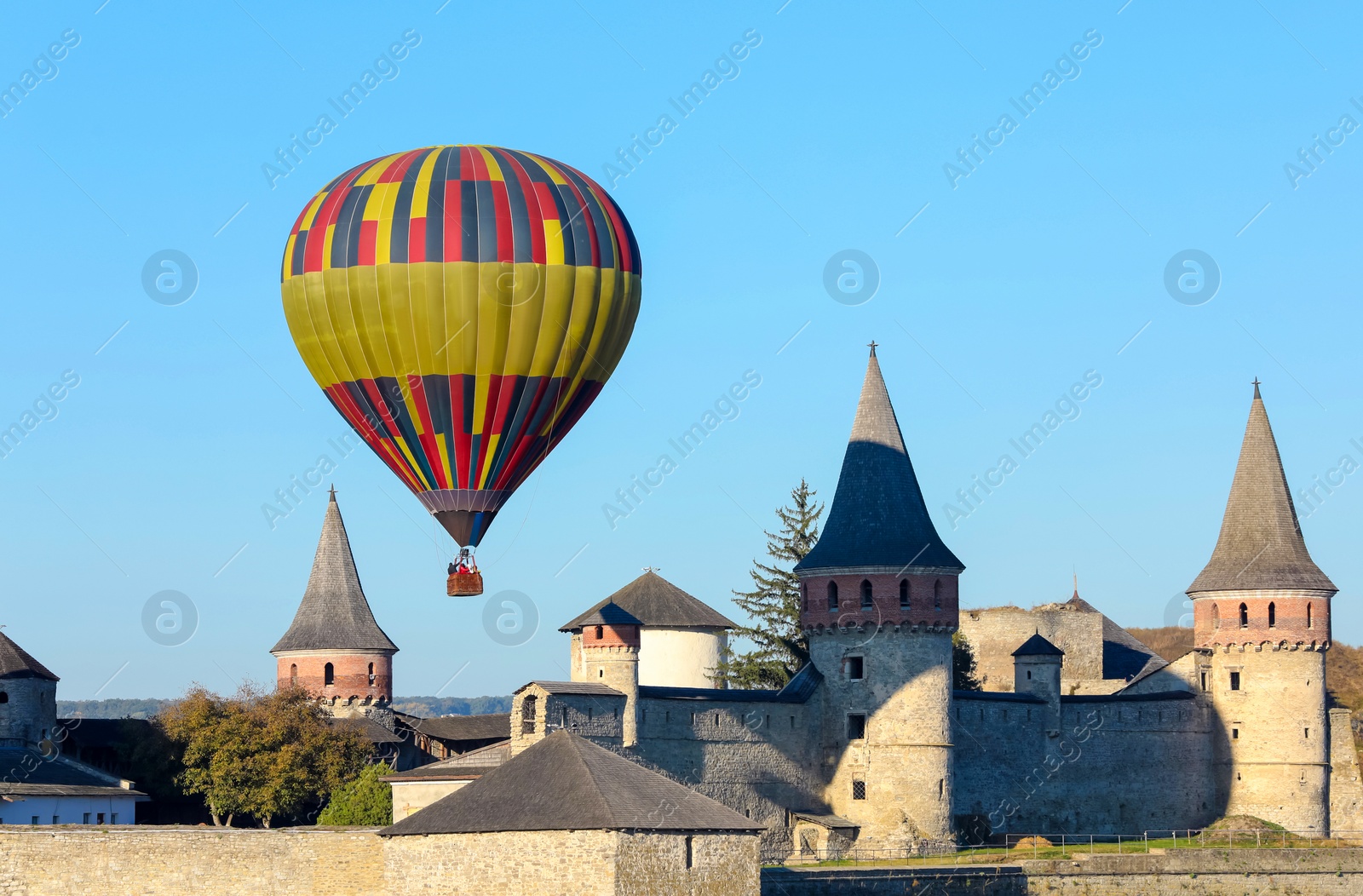Photo of KAMIANETS-PODILSKYI, UKRAINE - OCTOBER 06, 2018: Beautiful view of hot air balloon flying near Kamianets-Podilskyi Castle
