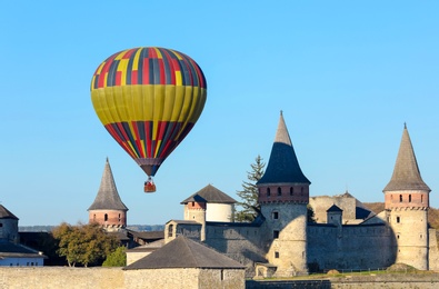 Photo of KAMIANETS-PODILSKYI, UKRAINE - OCTOBER 06, 2018: Beautiful view of hot air balloon flying near Kamianets-Podilskyi Castle