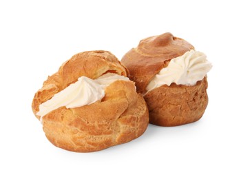 Delicious profiteroles with cream filling on white background