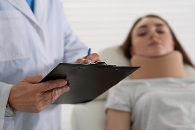 Orthopedist examining patient with injured neck in clinic, closeup