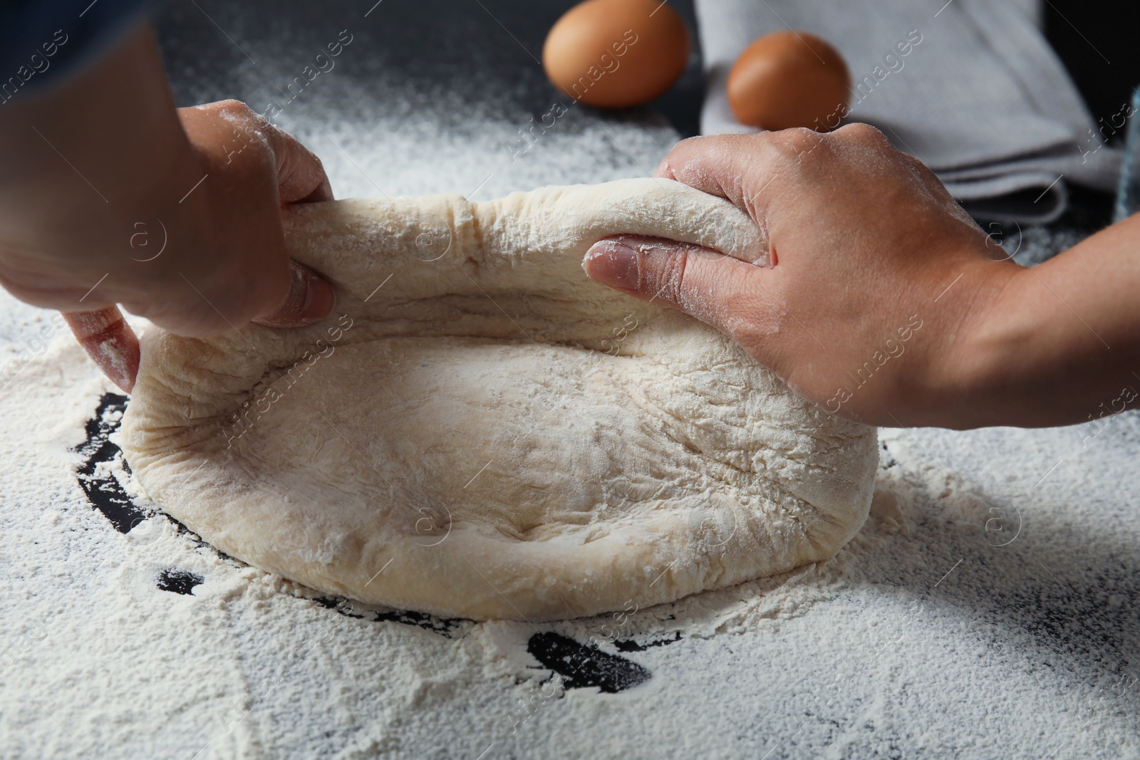 Photo of Woman kneading dough for pastry on table