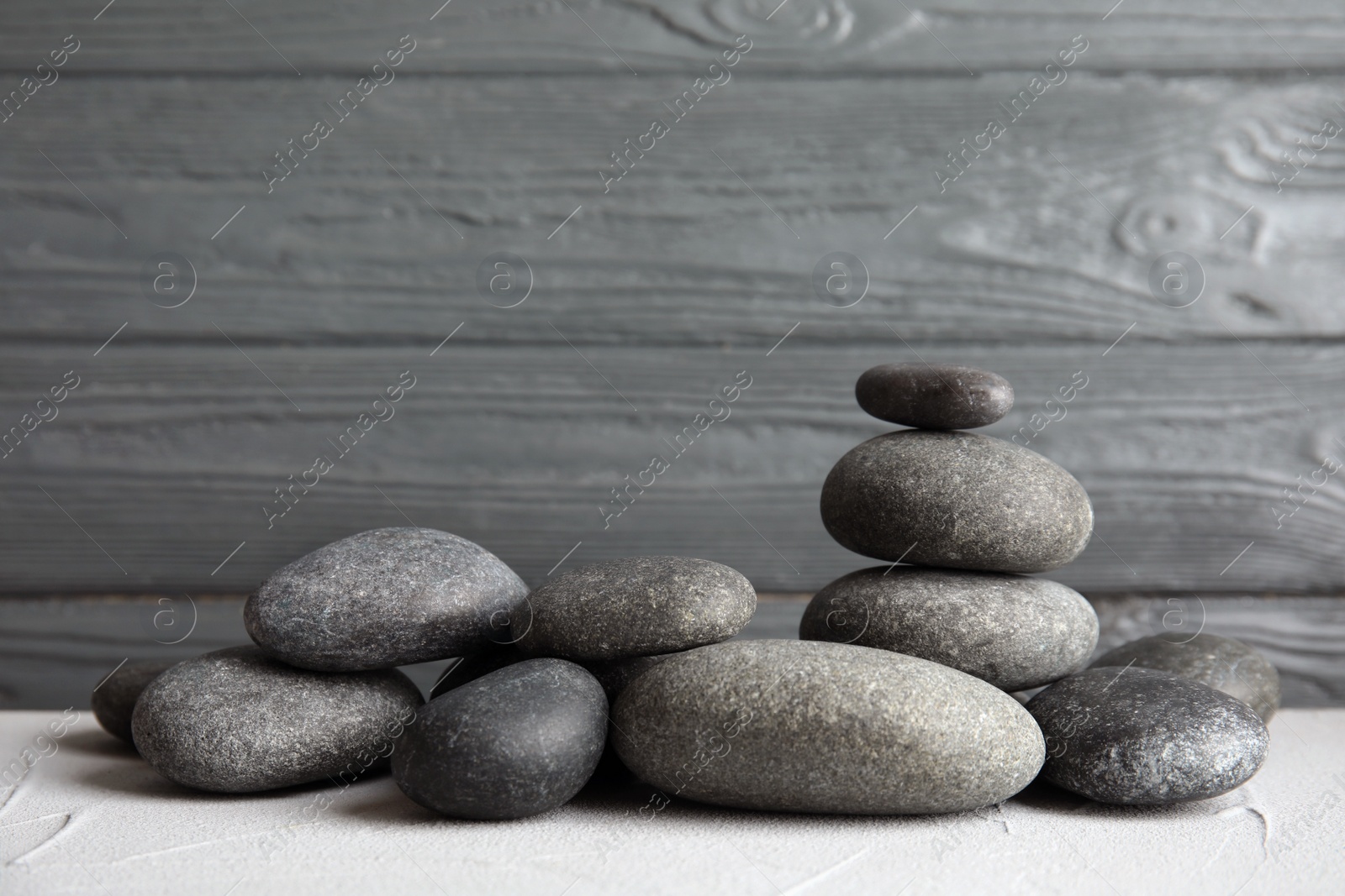 Photo of Zen stones on table against wooden background. Space for text