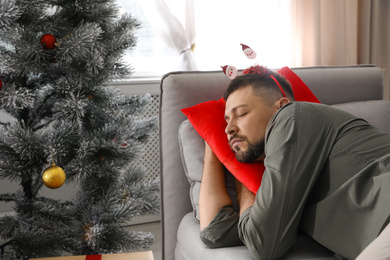 Photo of Man sleeping on sofa in room after New Year party