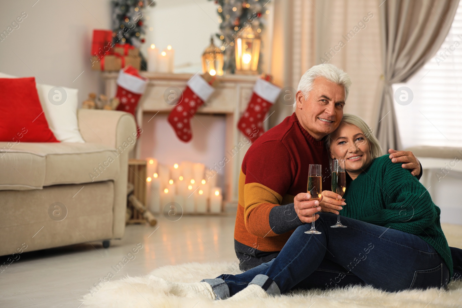 Photo of Happy mature couple with glasses of champagne at home. Christmas celebration