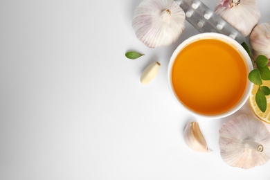 Composition with garlic and other cold remedies on white background, top view