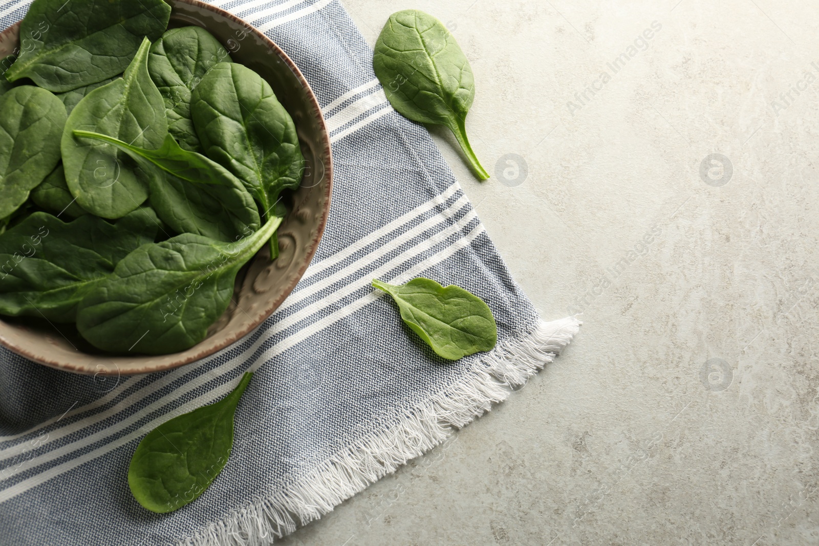 Photo of Fresh green healthy spinach leaves on light grey table, flat lay. Space for text